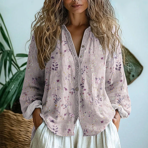 Woman wearing a pink embroidered floral print v-neck long sleeve blouse in a studio setting