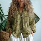 Woman wearing a green embroidered floral print v-neck long sleeve blouse in a studio setting
