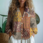 Woman wearing a yellow embroidered patchwork print v-neck long sleeve blouse in a studio setting
