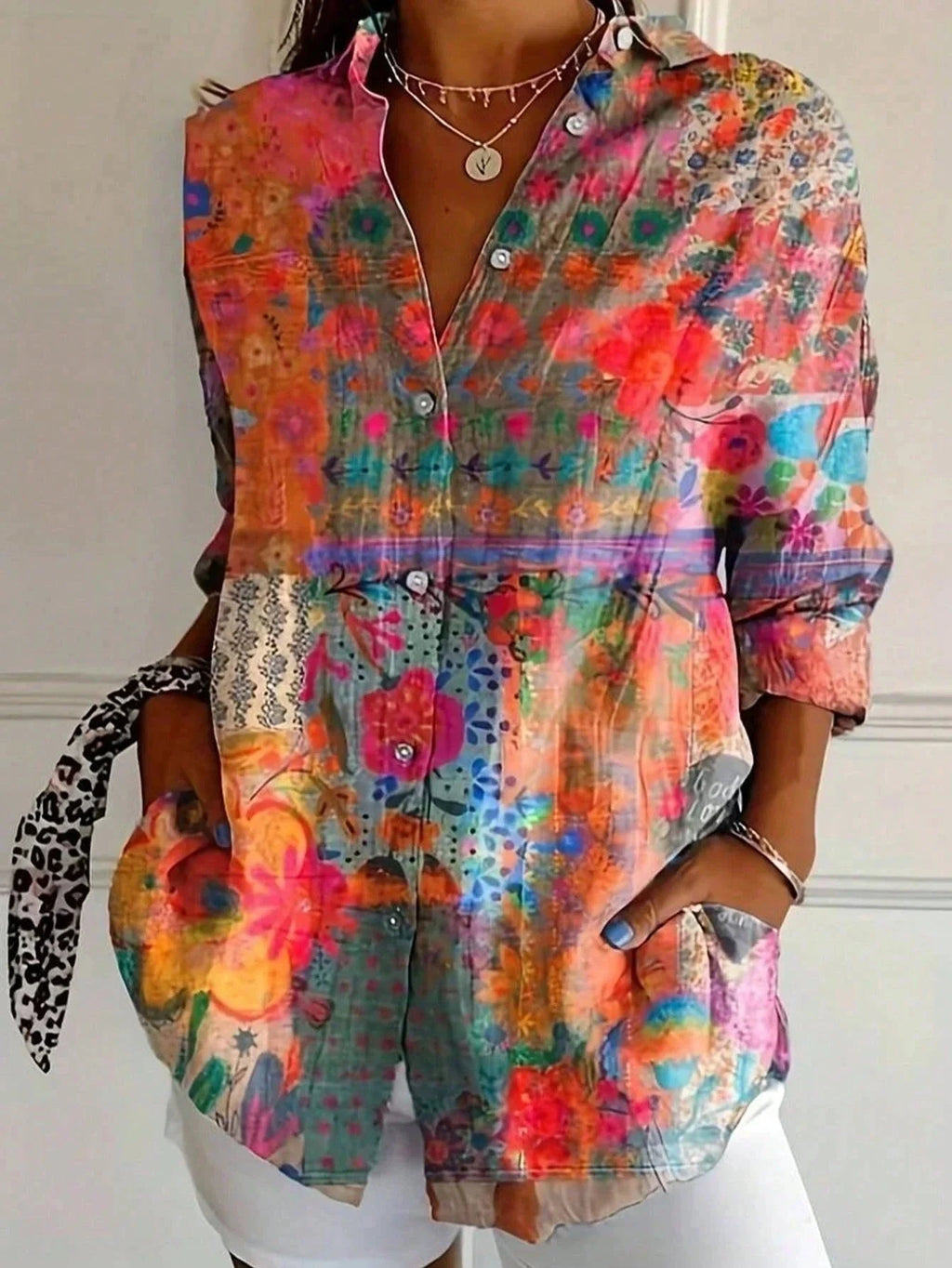 Close-up of an orange abstract floral print button-down blouse showing the print detail