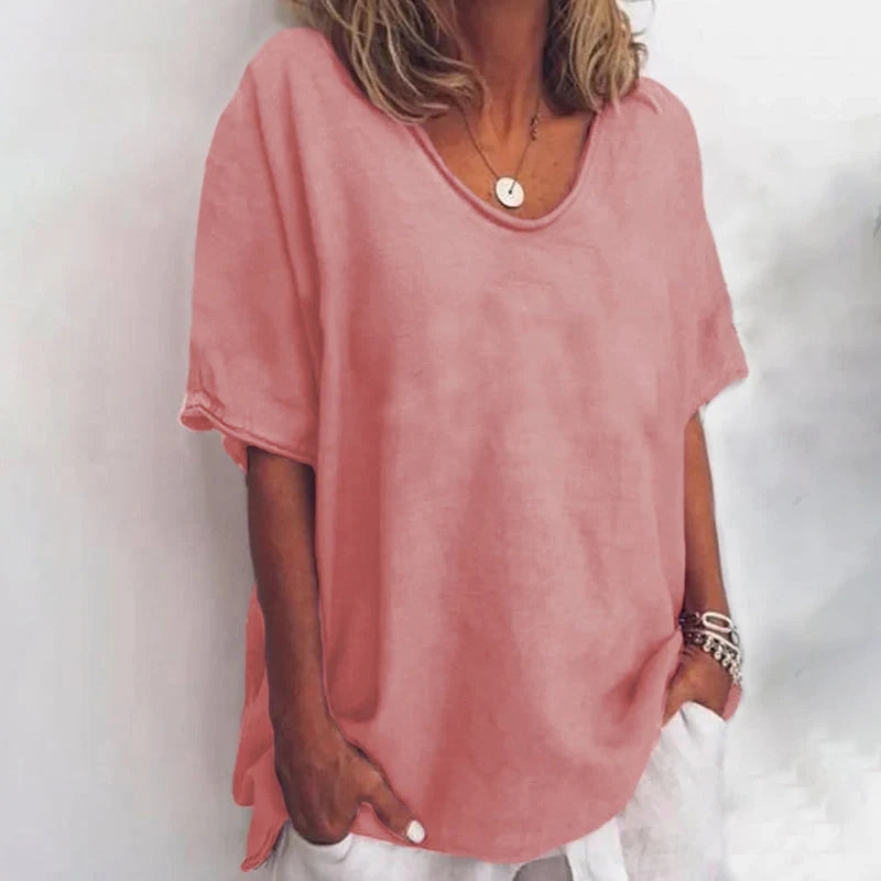 Woman wearing a dark pink v-neck short sleeve loose blouse in a studio setting