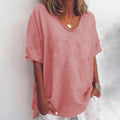 Woman wearing a dark pink v-neck short sleeve loose blouse in a studio setting