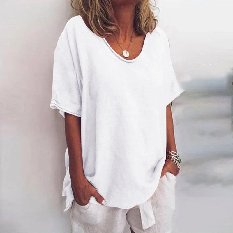 Woman wearing a white v-neck short sleeve loose blouse in a studio setting