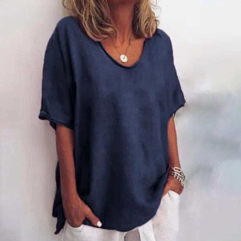 Woman wearing a blue v-neck short sleeve loose blouse in a studio setting