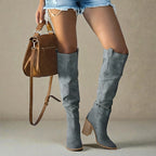 Woman wearing grey suede knee-high block heel boots with denim shorts