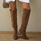 Woman wearing brown suede knee-high block heel boots, close-up view