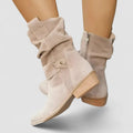 Beige zipper ankle boots with arch support in a studio setting
