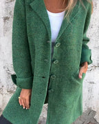 Woman wearing a green button-up long cardigan coat in a studio setting