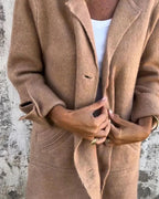 Woman wearing a khaki button-up long cardigan coat, close-up detail