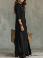 Woman wearing a black button-down maxi shirt dress, full-length front view in a studio setting