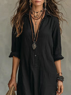 Close-up of a woman wearing a black button-down maxi shirt dress with layered necklaces