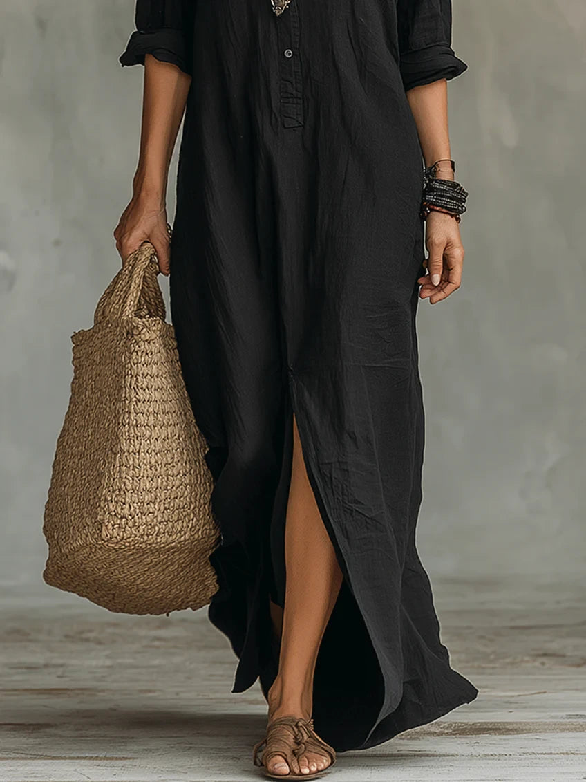 Woman wearing a black button-down maxi shirt dress, walking with a wicker tote bag in a studio setting