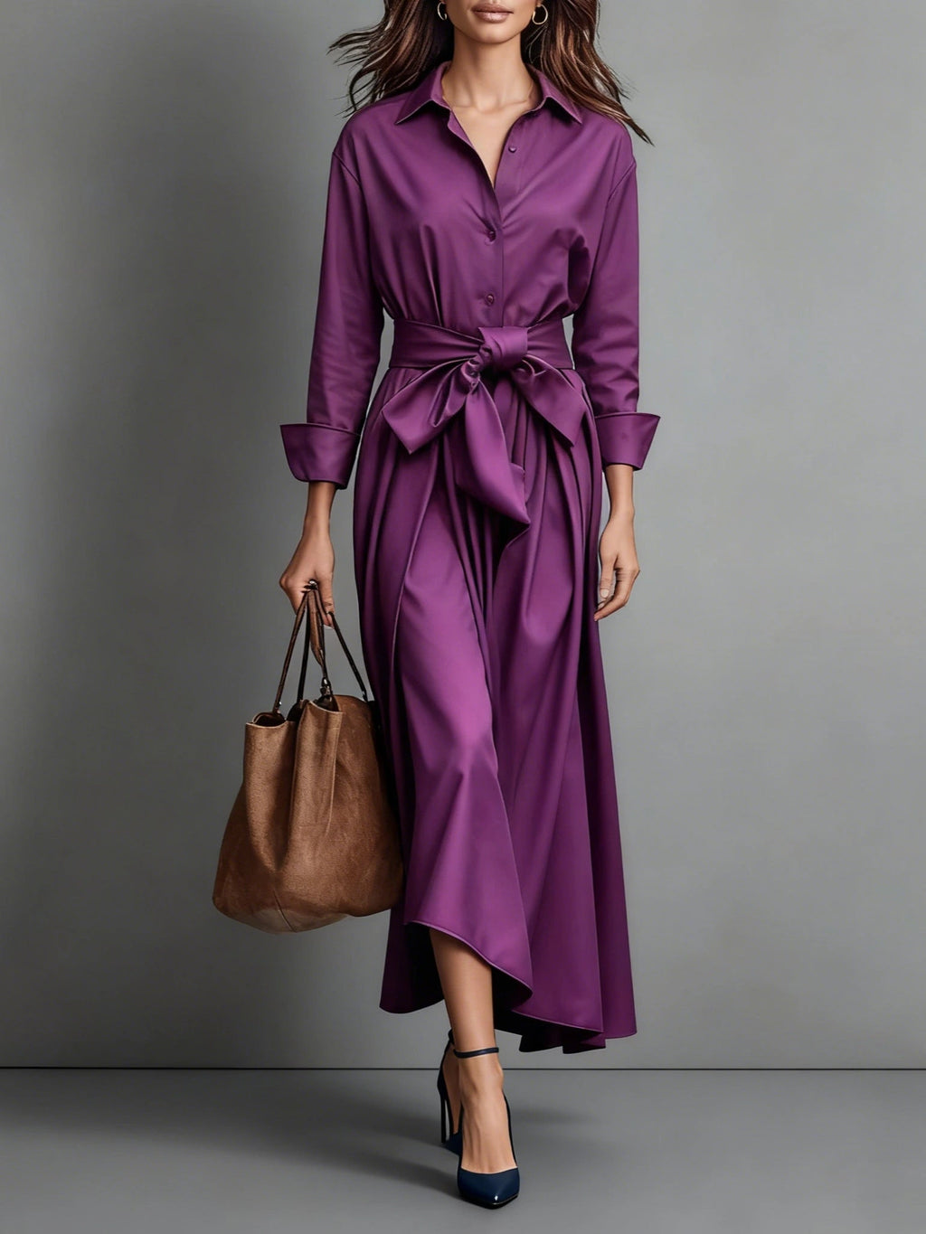 Woman wearing a purple bow-belted maxi shirt dress with a tote bag, studio setting