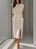 Woman wearing a beige button front sleeveless midi dress in a studio setting