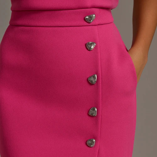 Close-up of a bright pink button front sleeveless midi dress showing the button detail