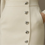Close-up of a beige button front sleeveless midi dress showing the button detail