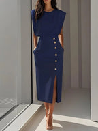 Woman wearing a blue button front sleeveless midi dress in a studio setting