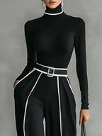 Close-up of black wide-leg trousers with white contrast piping and belt detail