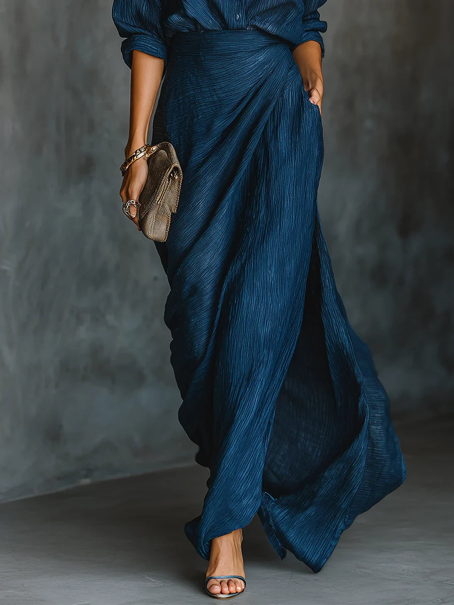 Woman wearing a dark blue elegant long-sleeve wrap maxi dress, close-up of the skirt