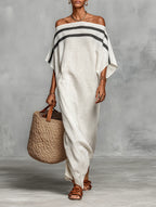 Woman wearing a white off-shoulder batwing maxi dress in a studio setting