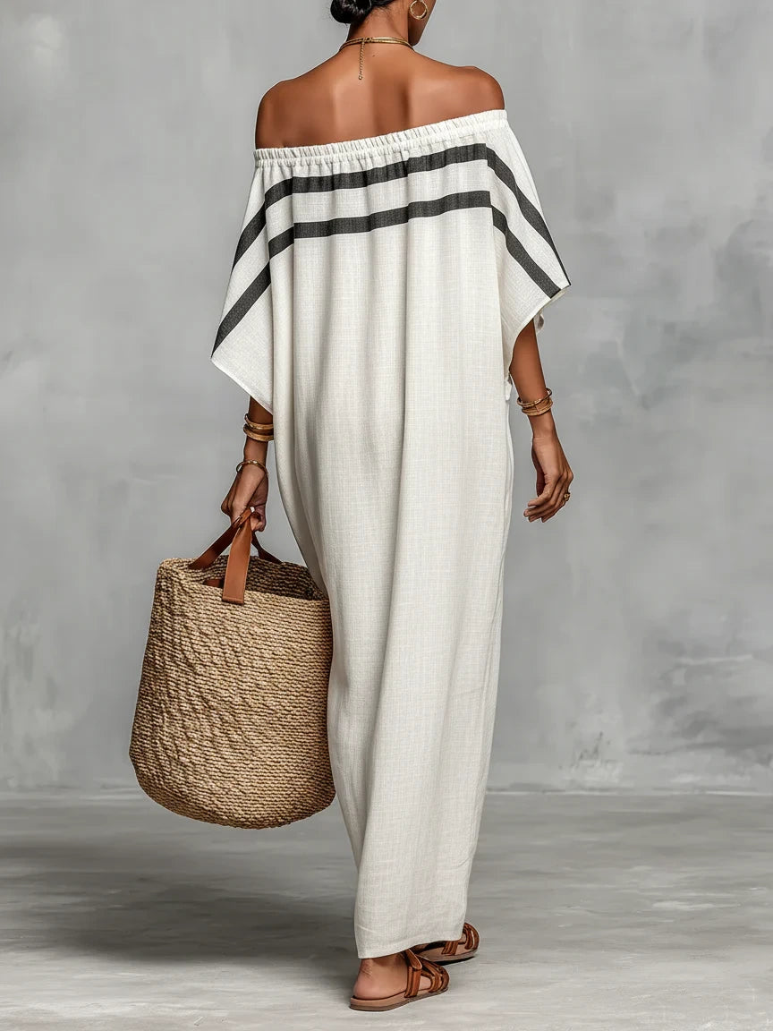 Woman wearing a white off-shoulder batwing maxi dress in an outdoor setting