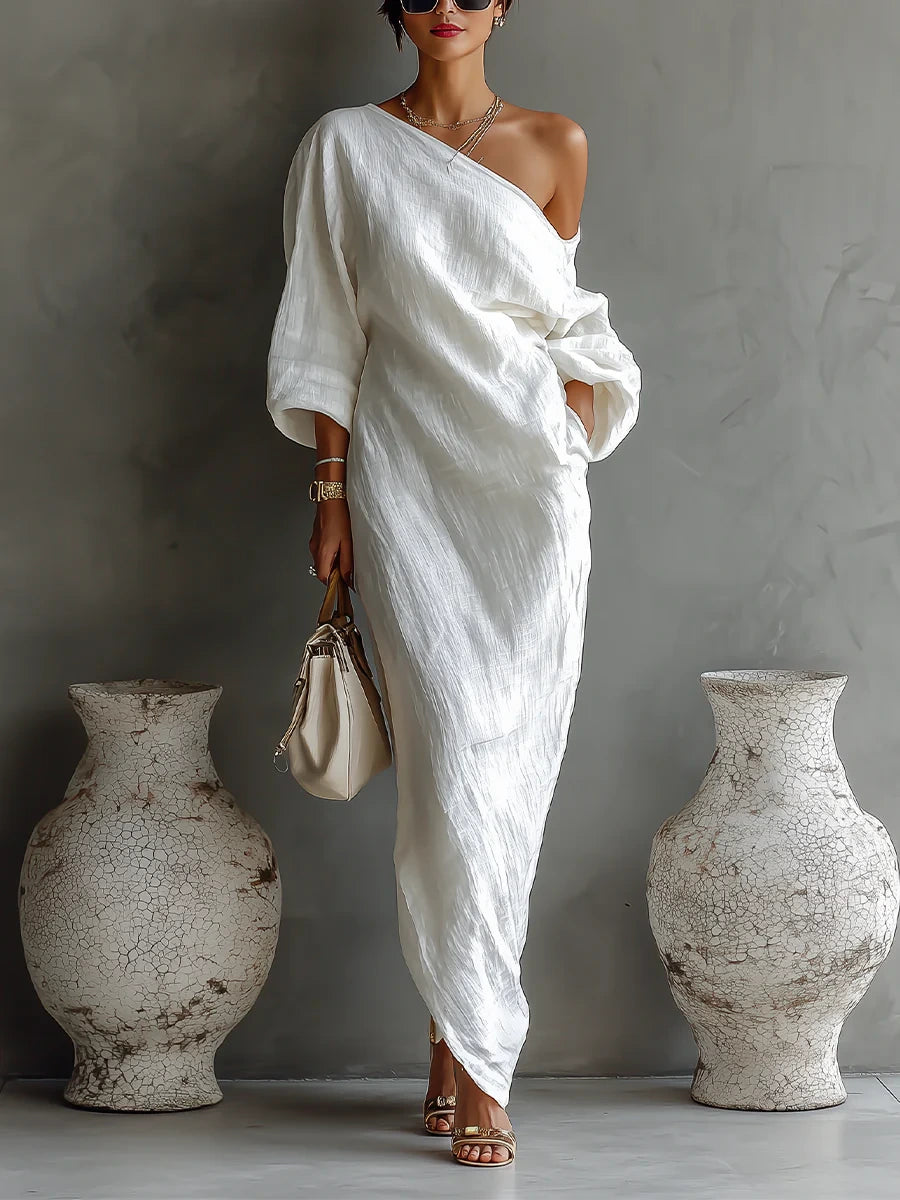 Woman wearing a white one-shoulder draped maxi dress, front view