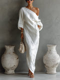 Woman wearing a white one-shoulder draped maxi dress, front view