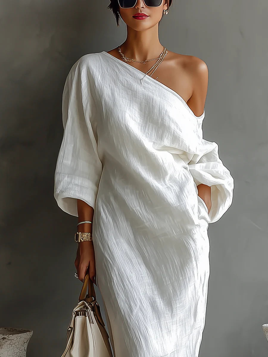 Woman wearing a white one-shoulder draped maxi dress, close-up front view