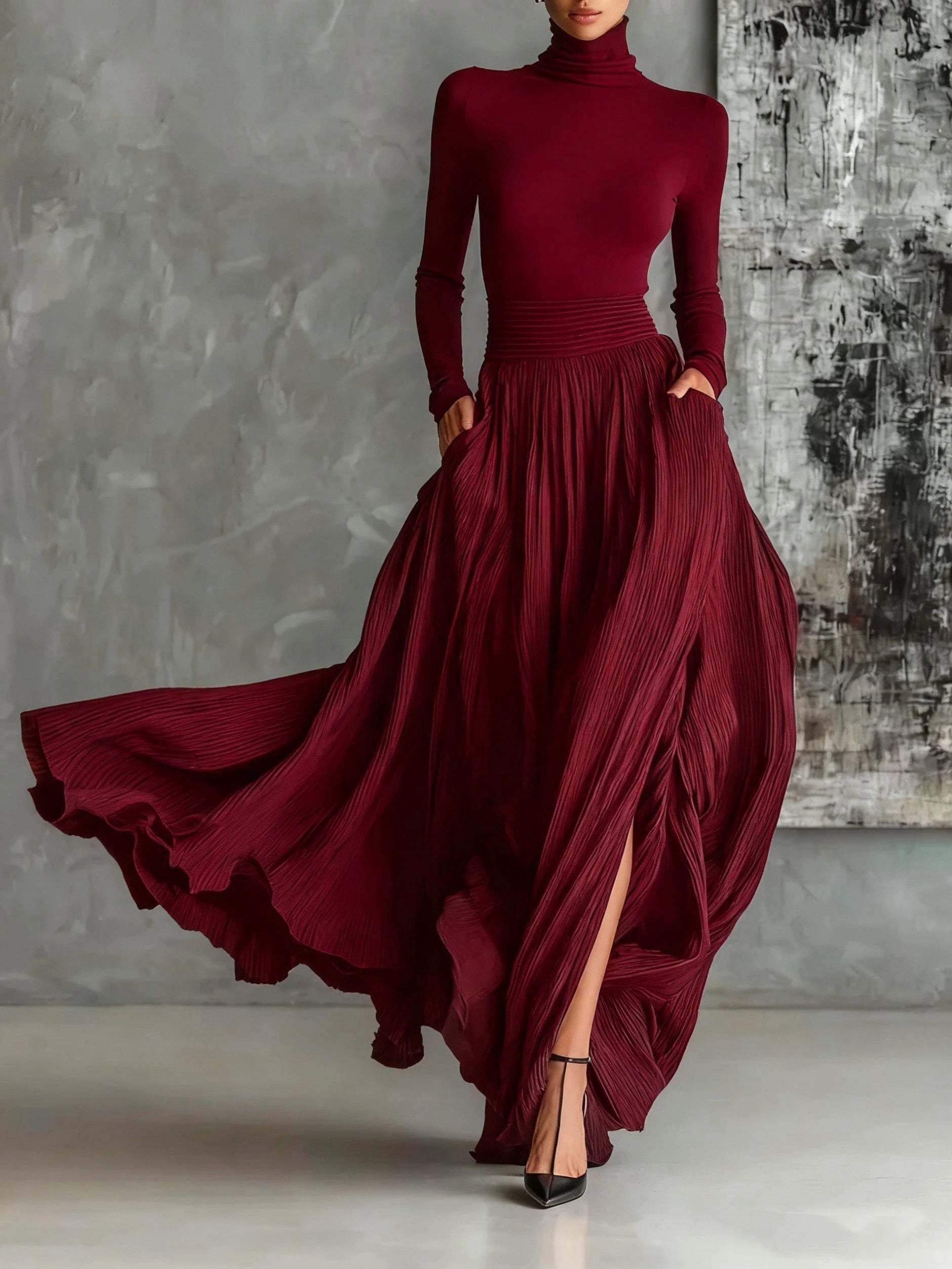 Woman wearing a dark red pleated maxi skirt with a dark red turtleneck top, studio setting