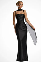 Woman wearing a black square neck ruched maxi dress with sheer wrap, front view