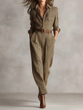 Woman wearing a brown checkered pattern jumpsuit with a belt, studio setting