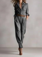 Woman wearing a gray checkered pattern jumpsuit with a belt, studio setting