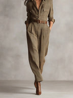 Woman wearing a brown checkered pattern jumpsuit, walking in a studio setting