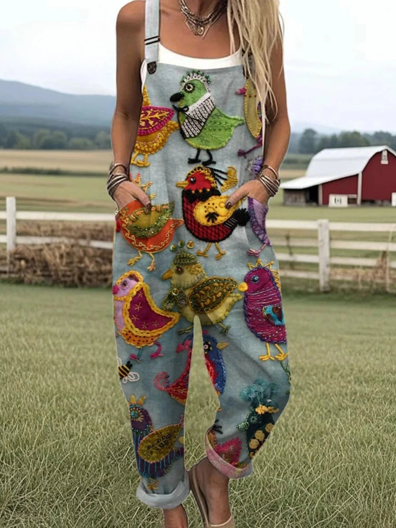 Woman wearing a light blue-grey overall jumpsuit with a colorful vintage bird print on a farm