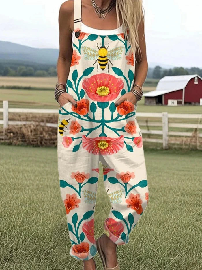 Woman wearing a cream sleeveless jumpsuit with a pink floral and bee print, front view on a farm