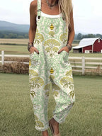 Woman wearing a sage-green overall jumpsuit with a gold floral damask print on a farm