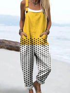 Woman wearing a yellow polka dot color-block sleeveless overall jumpsuit standing on a rocky beach