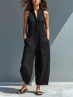 Woman wearing a black minimalist sleeveless jumpsuit in a studio setting