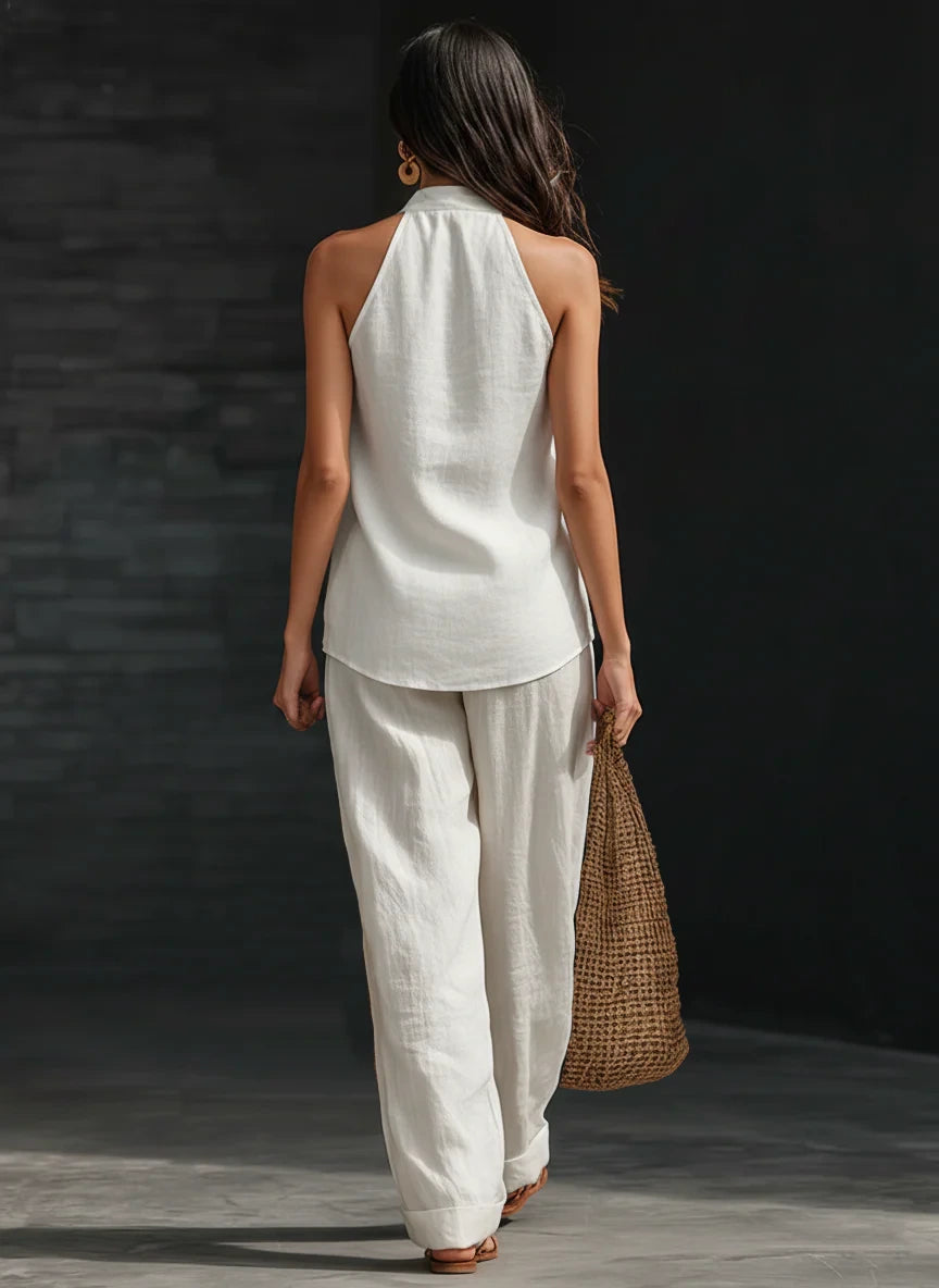 Woman wearing a white sleeveless wide-leg jumpsuit in an outdoor setting