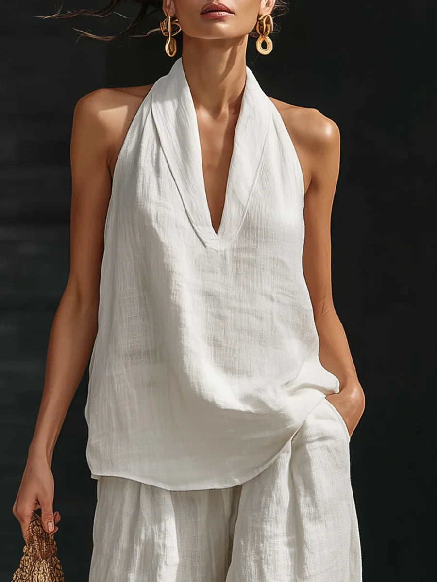 Woman wearing a white sleeveless wide-leg jumpsuit in a lifestyle setting