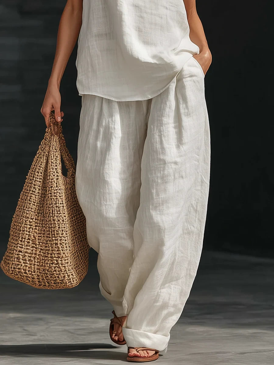 Close-up of a white sleeveless wide-leg jumpsuit showing the fabric detail