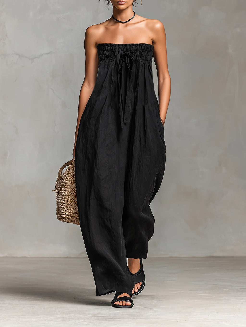 Woman wearing a black strapless jumpsuit in a studio setting
