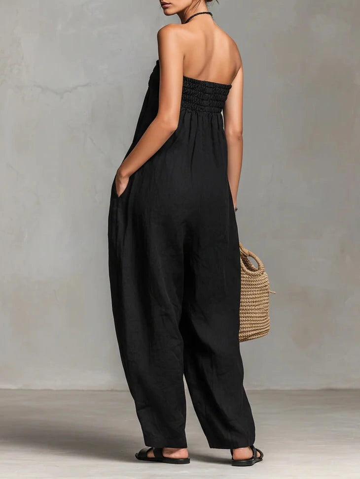 Woman wearing a black strapless jumpsuit in an outdoor setting