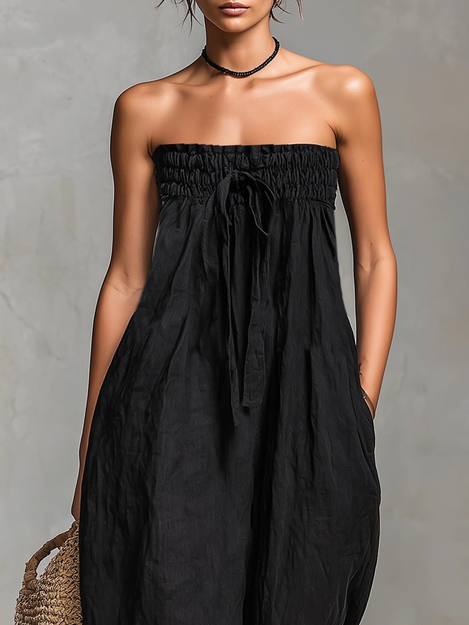Woman wearing a black strapless jumpsuit in a lifestyle setting
