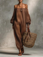 Woman wearing a brown strapless long sleeve jumpsuit in a studio setting