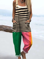 Woman wearing a striped and color-block jumpsuit standing on a sandy beach
