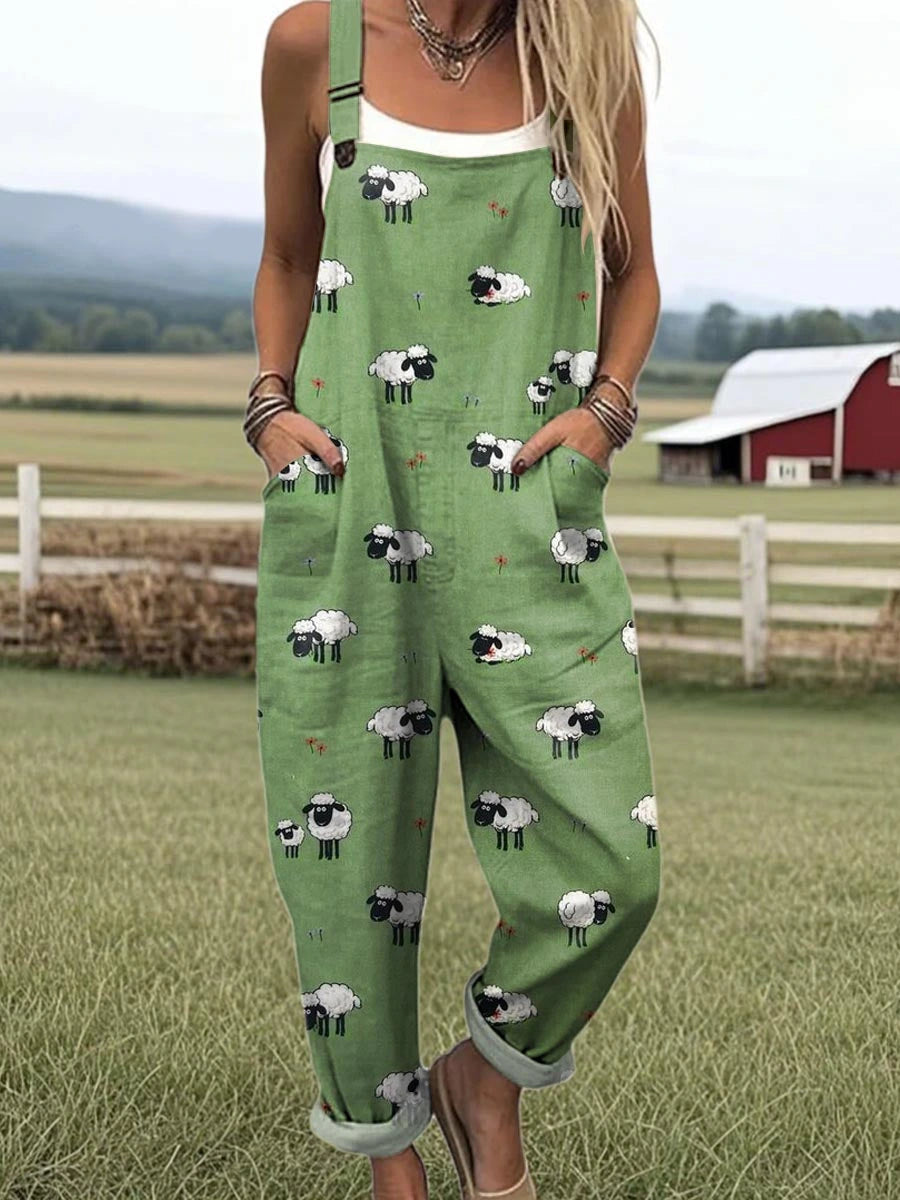 Woman wearing a green jumpsuit with a white sheep print standing in a farm field near a red barn