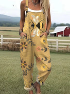 Woman wearing a tan-mustard overall jumpsuit with a bee and floral print on a farm