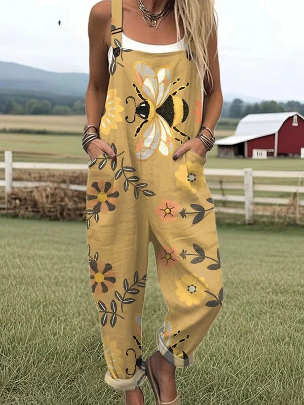 Woman wearing a tan-mustard overall jumpsuit with a bee and floral print on a farm