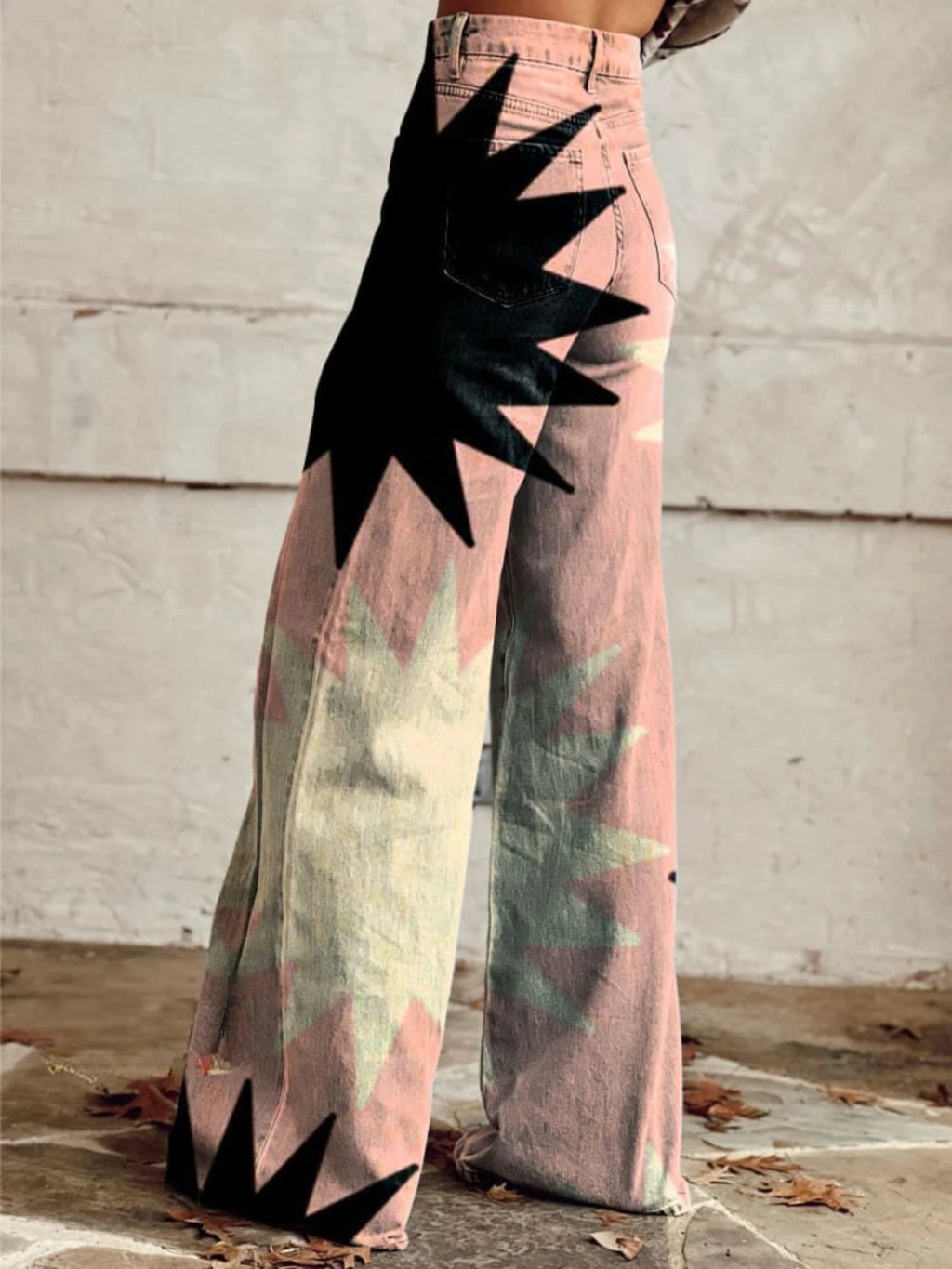 Close-up of pink bohemian chic high-waisted pants with a black star print, back view